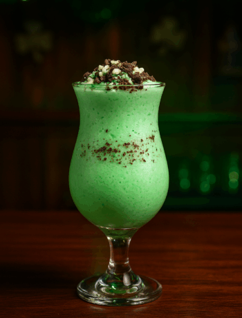 Frozen Leprechaun cocktail recipe in a hurricane glass with Peppermint Pattie garnish and chocolate shavings