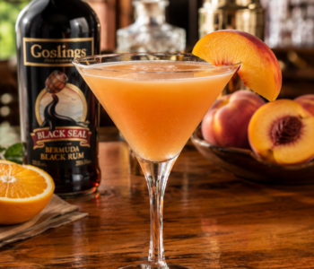 A peach melissa cocktail recipe served in a chilled cocktail glass with a fresh peach slice on a polished neighborhood bar counter.