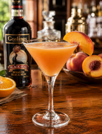 A peach melissa cocktail recipe served in a chilled cocktail glass with a fresh peach slice on a polished neighborhood bar counter.