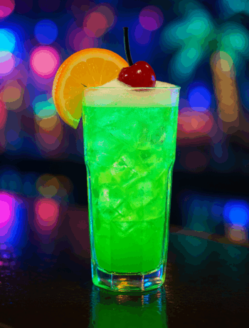 Green Bull cocktail recipe in a Collins glass with ice, orange garnish, and neon tropical lighting Title: Green Bull Cocktail Recipe in a Collins Glass