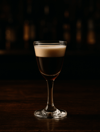 Reservoir Dog cocktail recipe in a cordial glass with creamy Bailey’s and Jägermeister layers on a dark bar